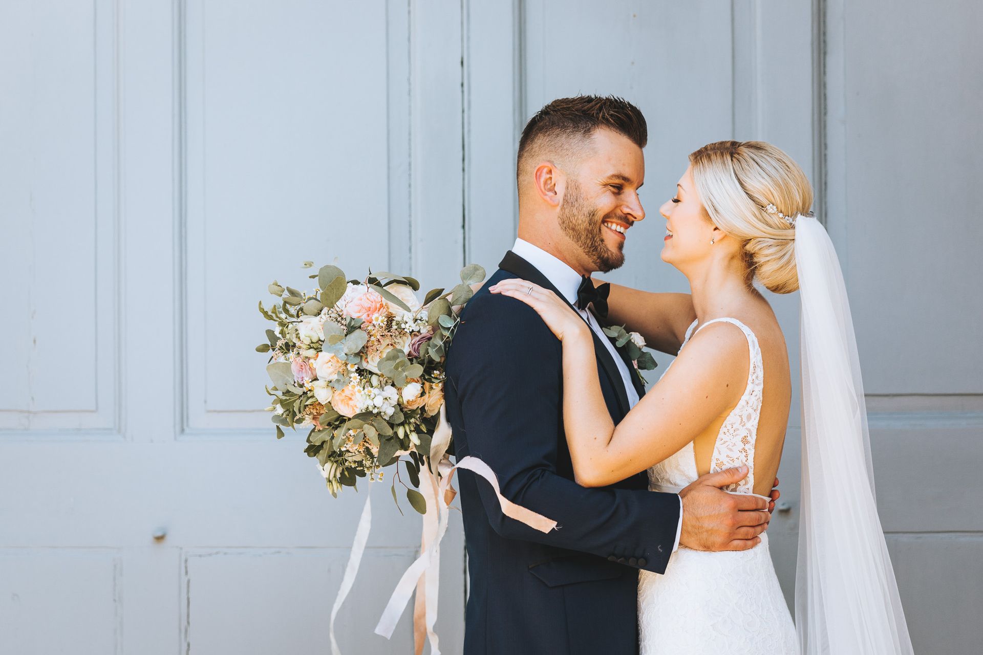 a bride and groom are standing next to each other and looking at each other .