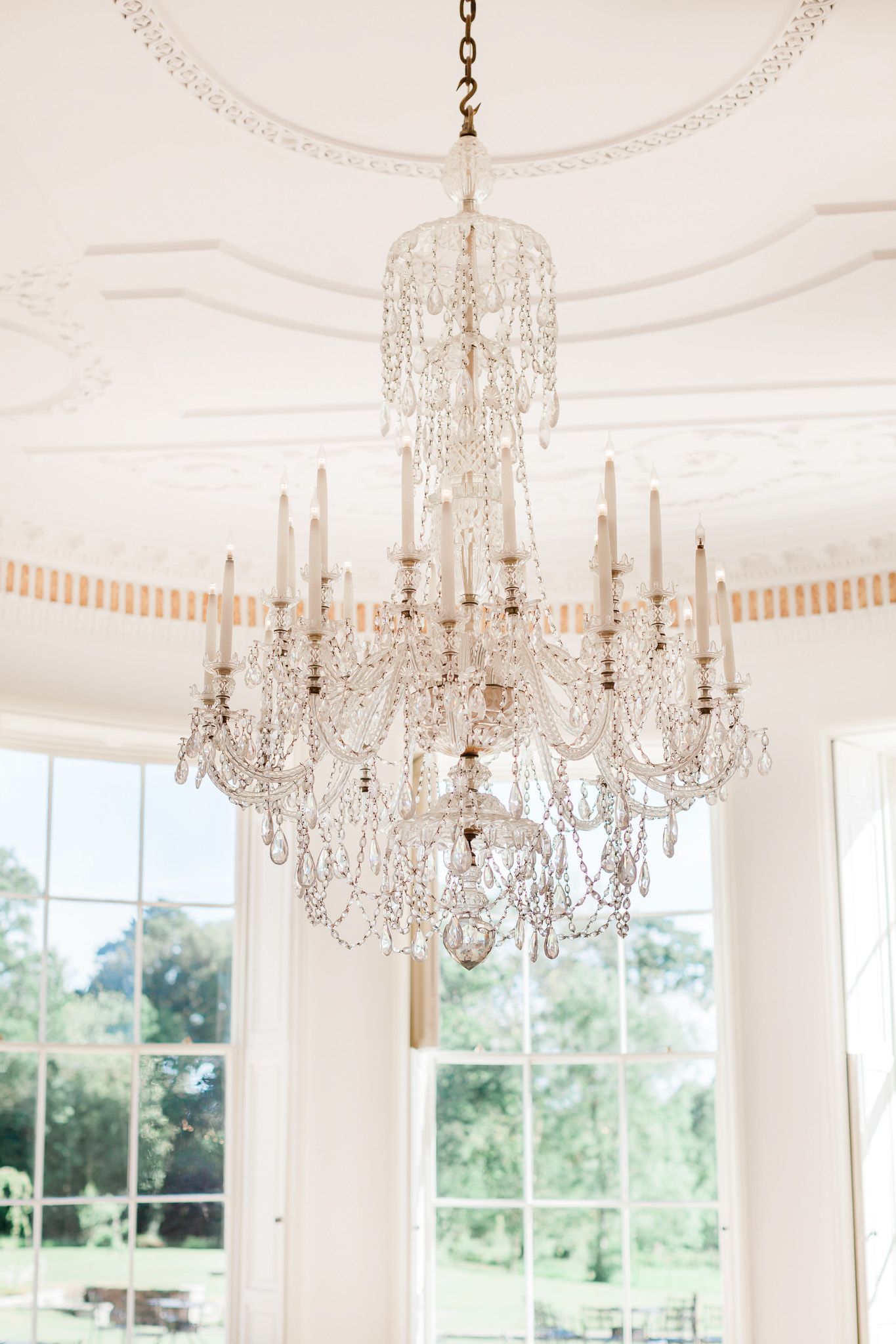 a large chandelier is hanging from the ceiling in a room with a window.
