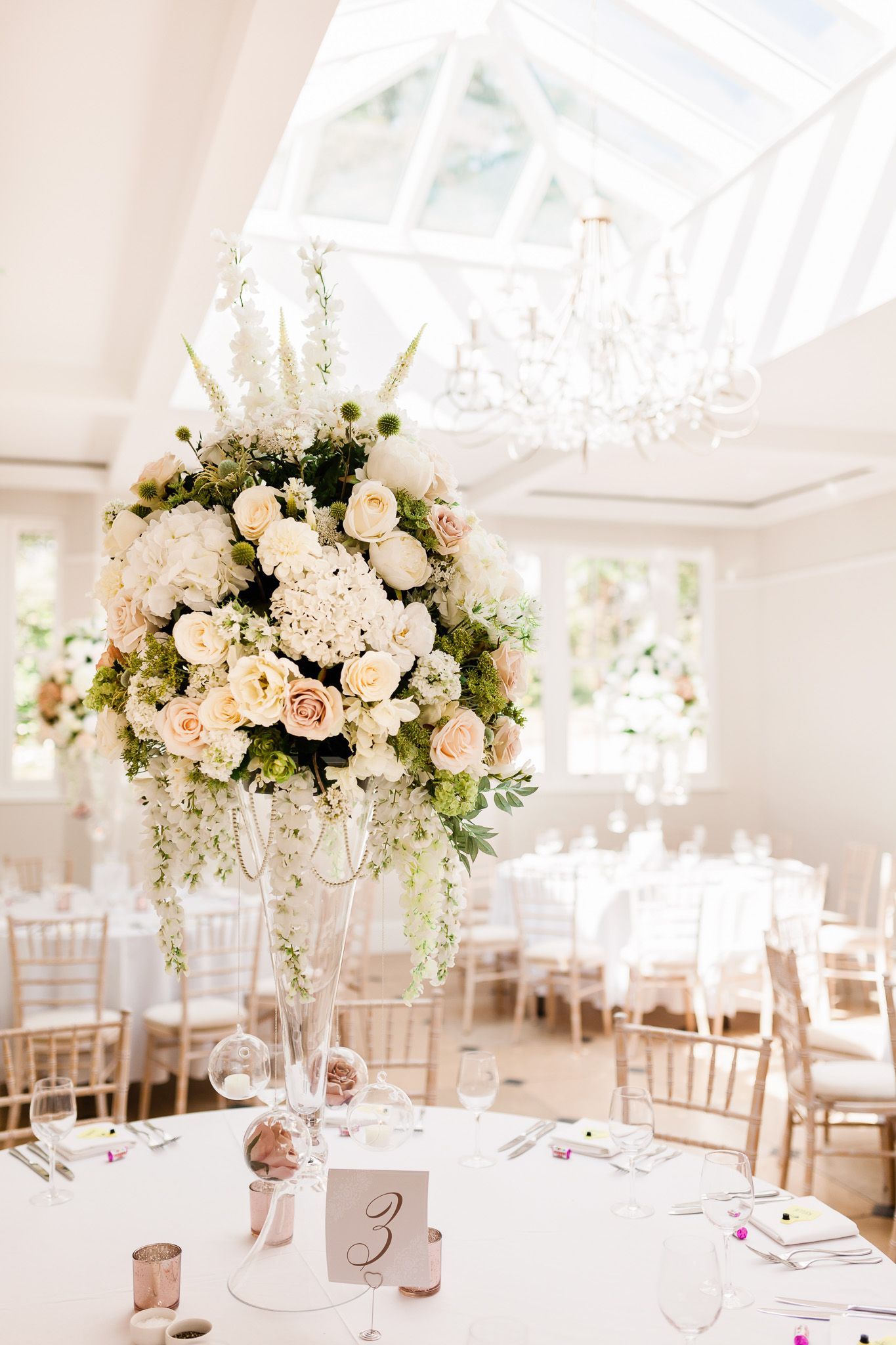 a large vase filled with white flowers is sitting on top of a table.