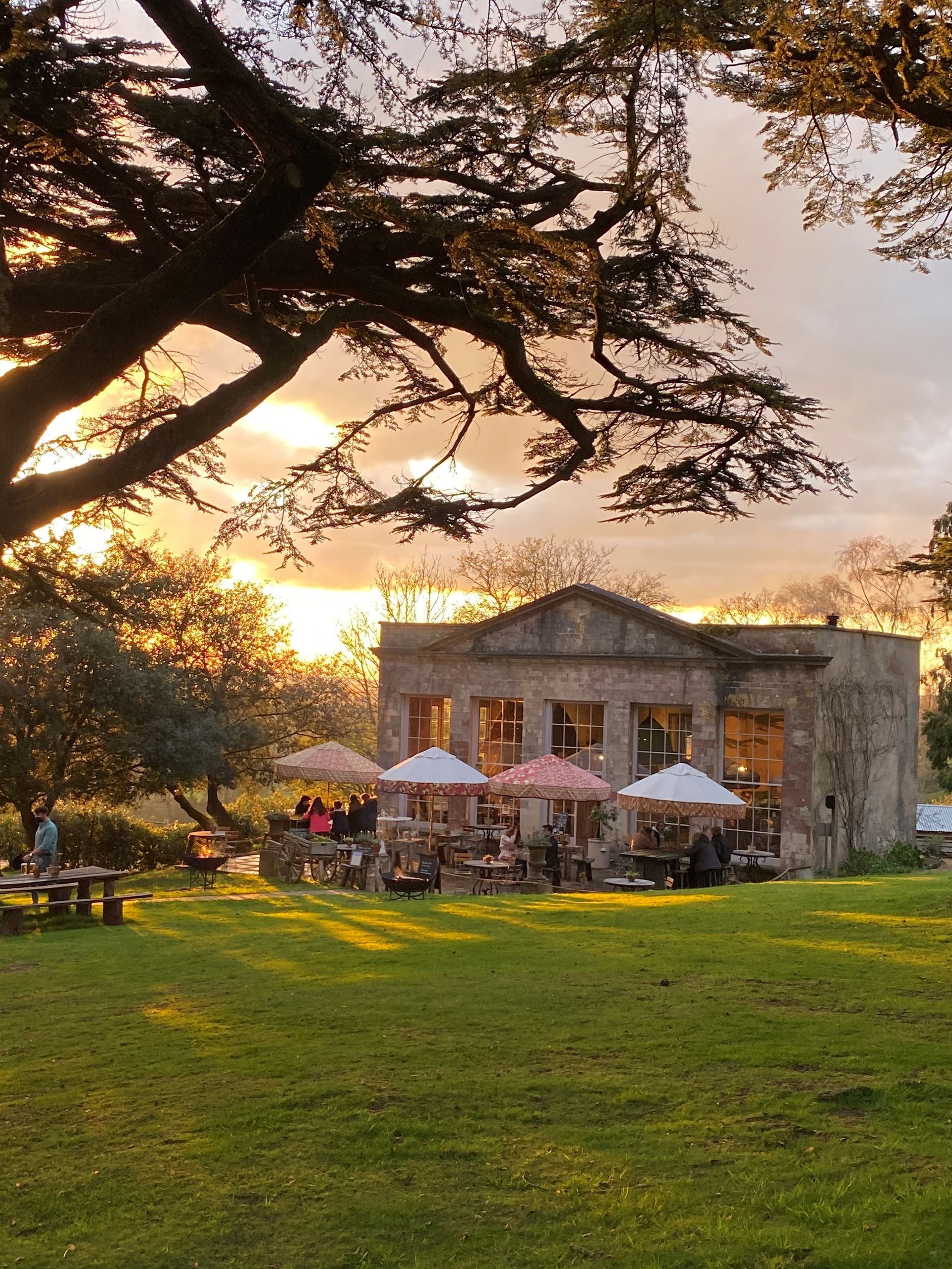 a large building with tables and umbrellas in front of it
