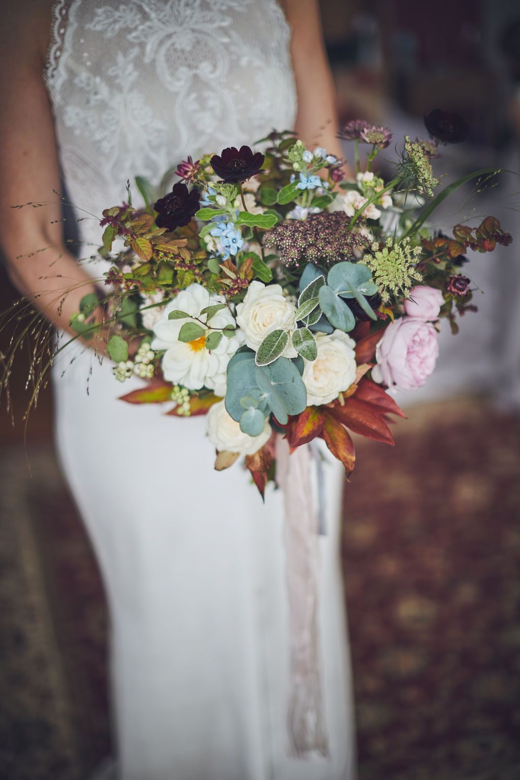 a bride in a white dress is holding a bouquet of flowers .
