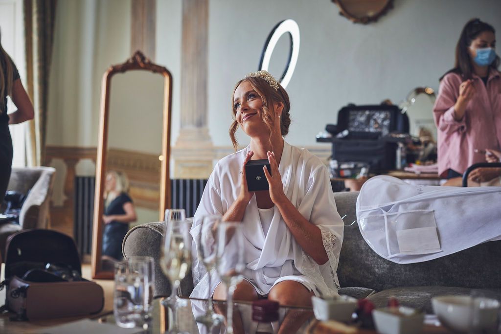a woman is sitting on a couch looking at her phone .