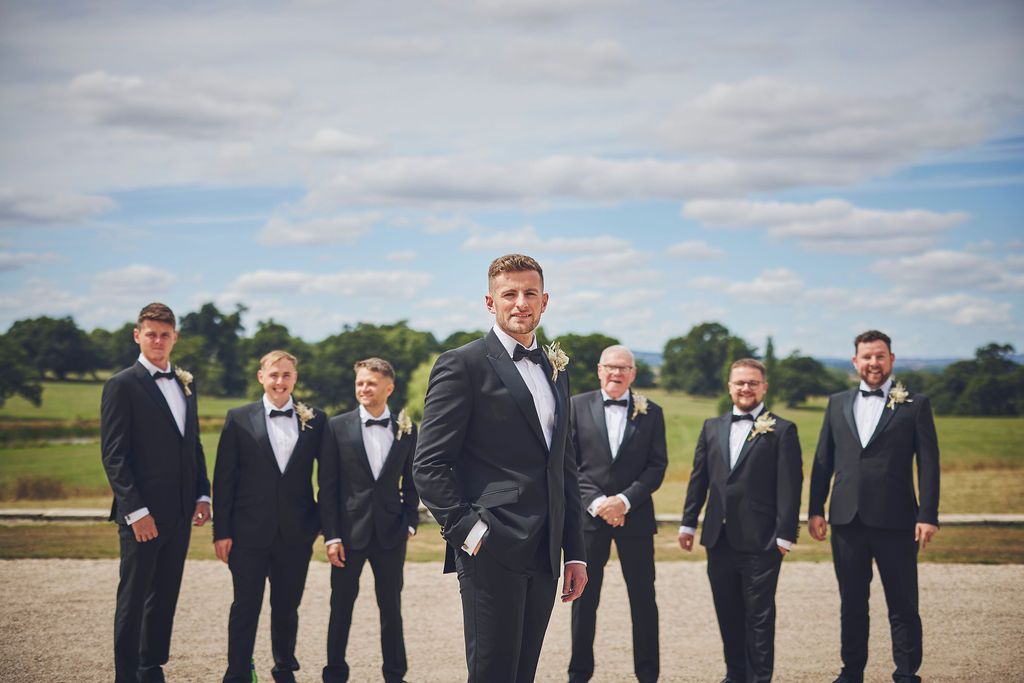 a groom and his groomsmen are posing for a picture .