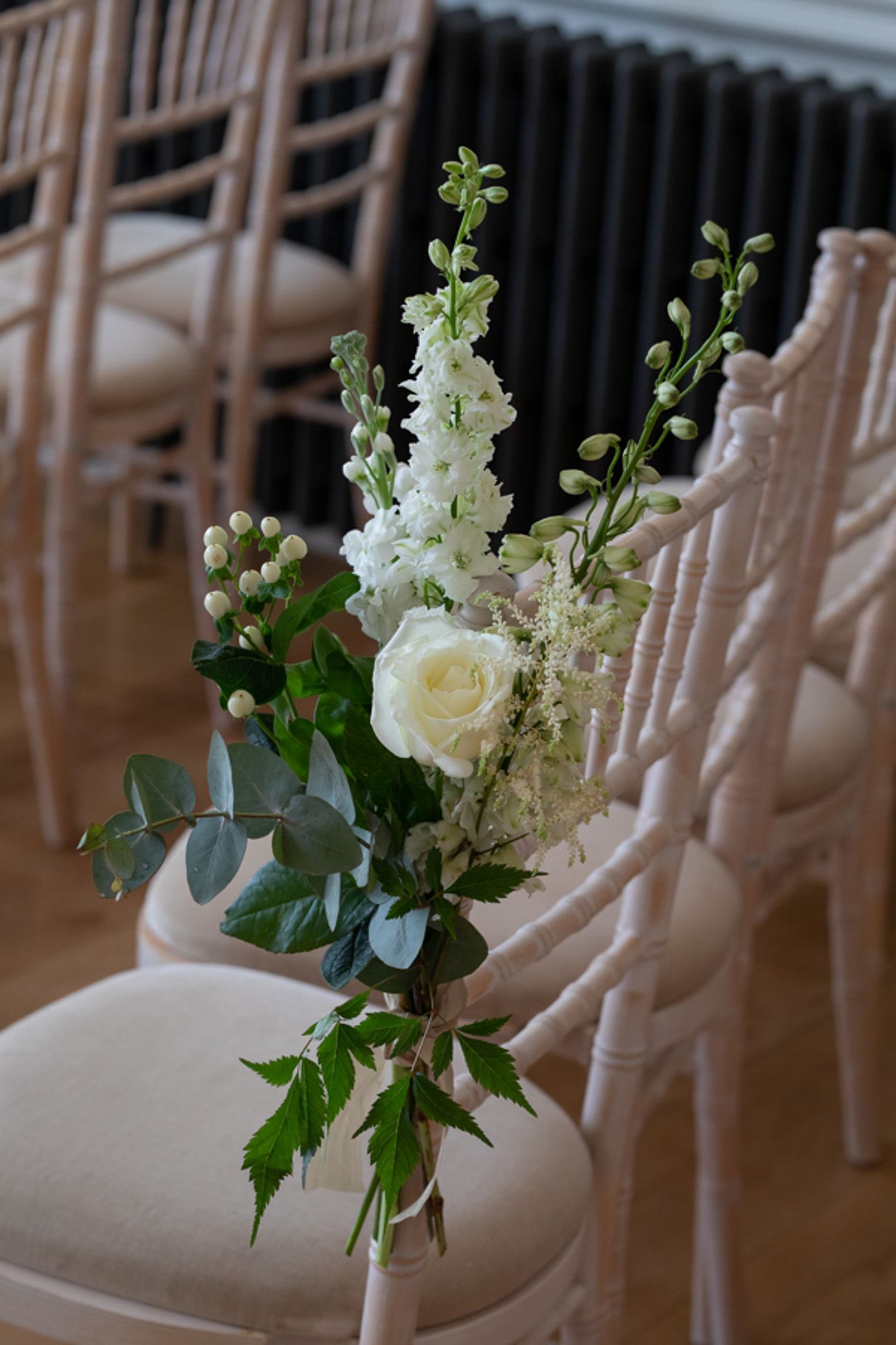 a row of chairs with white flowers on them .