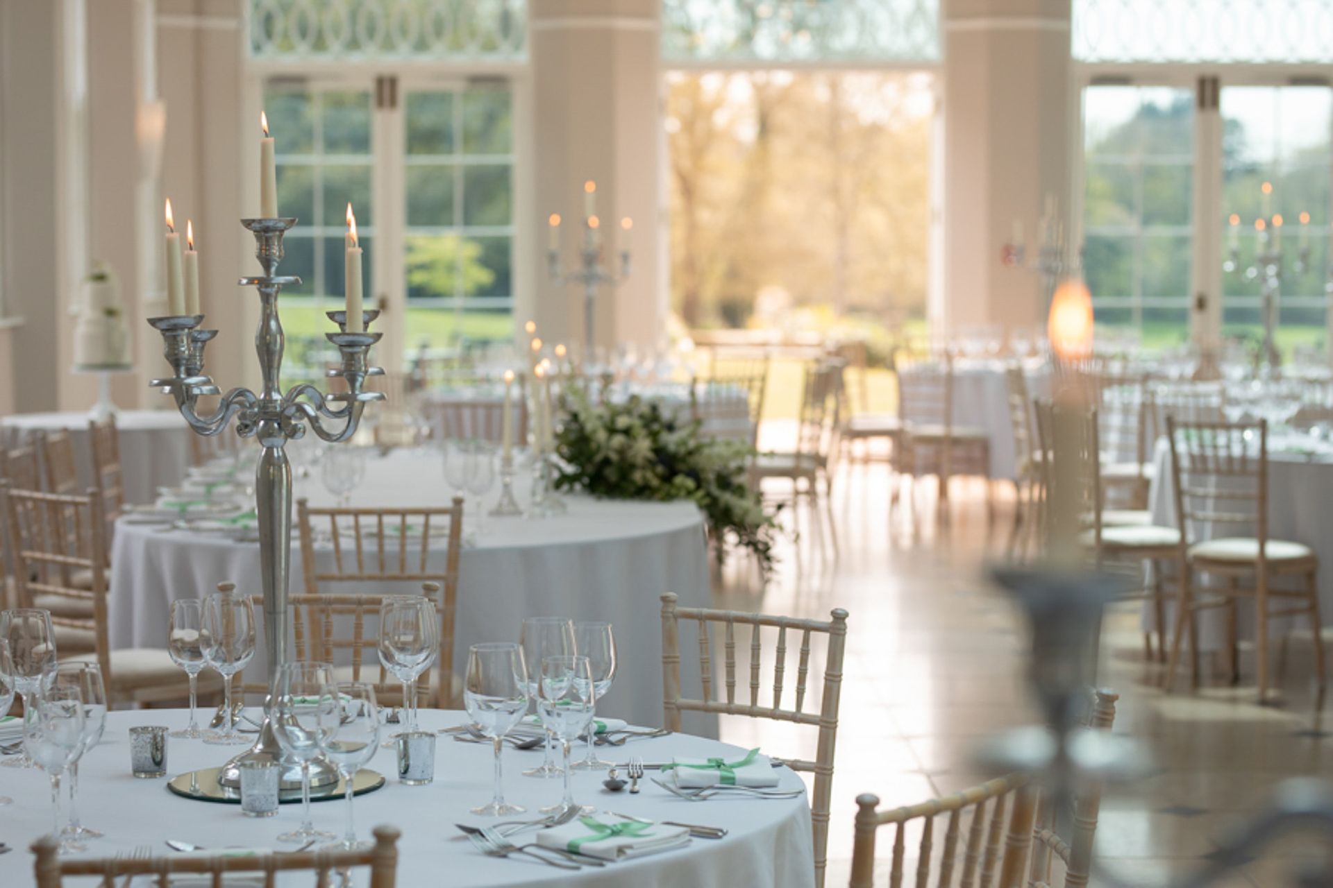 a large room with tables and chairs set up for a wedding reception .