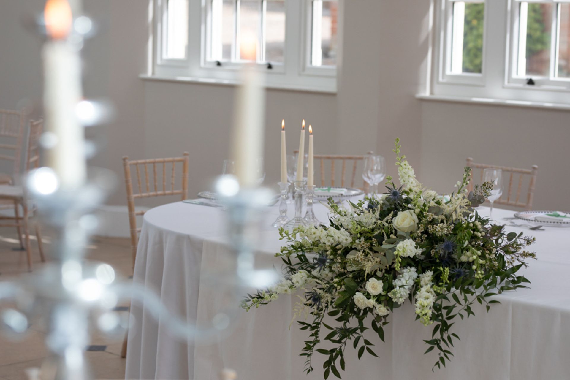 a table with flowers and candles on it in a room .