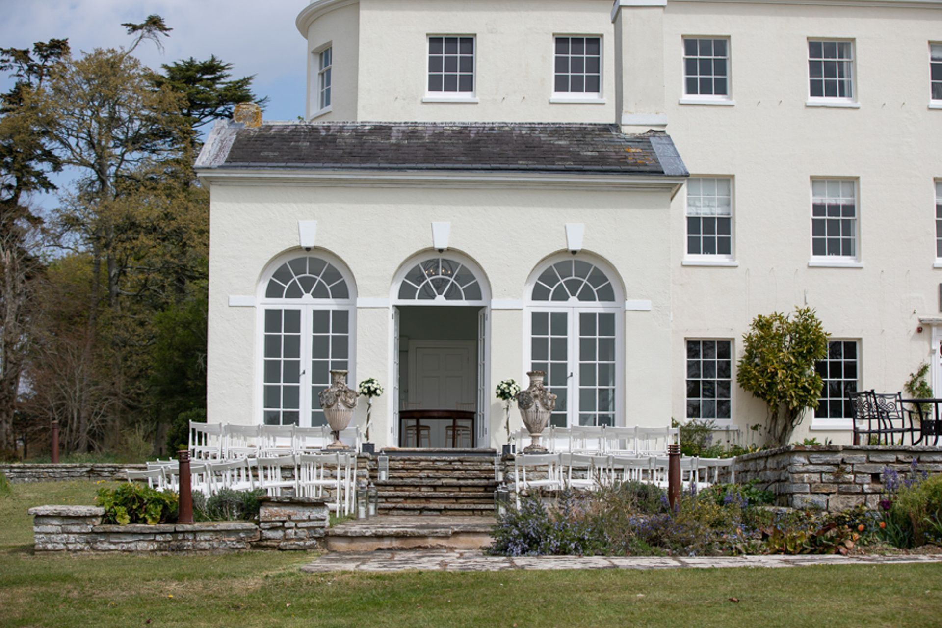 a large white house with arched windows and stairs