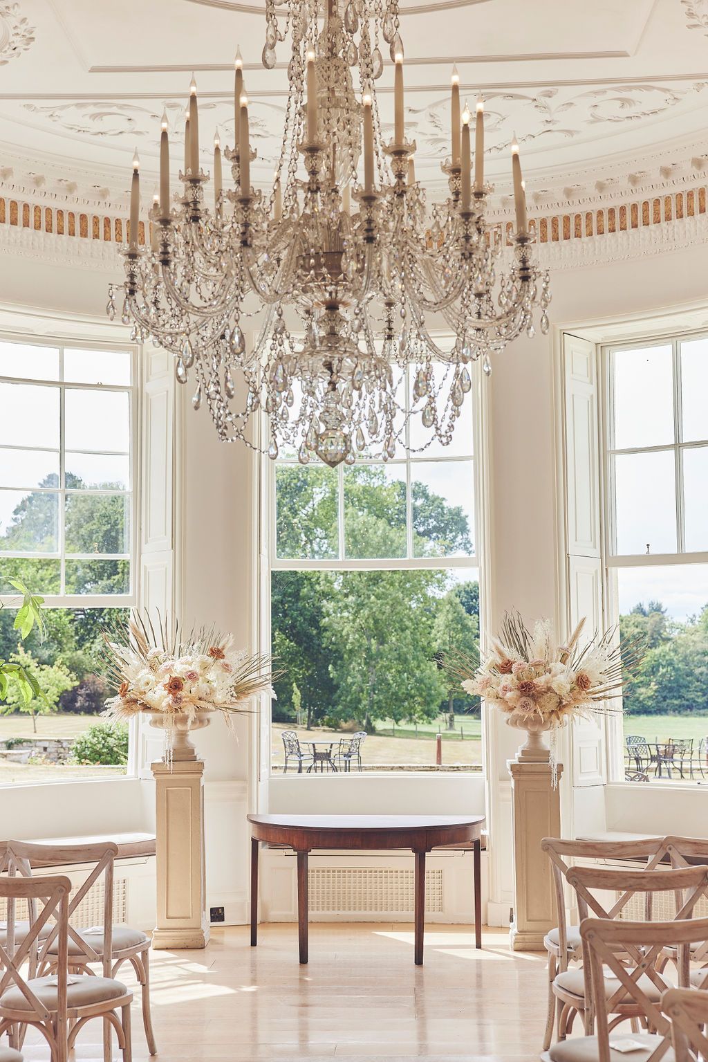 a room with a table and chairs and a chandelier hanging from the ceiling .