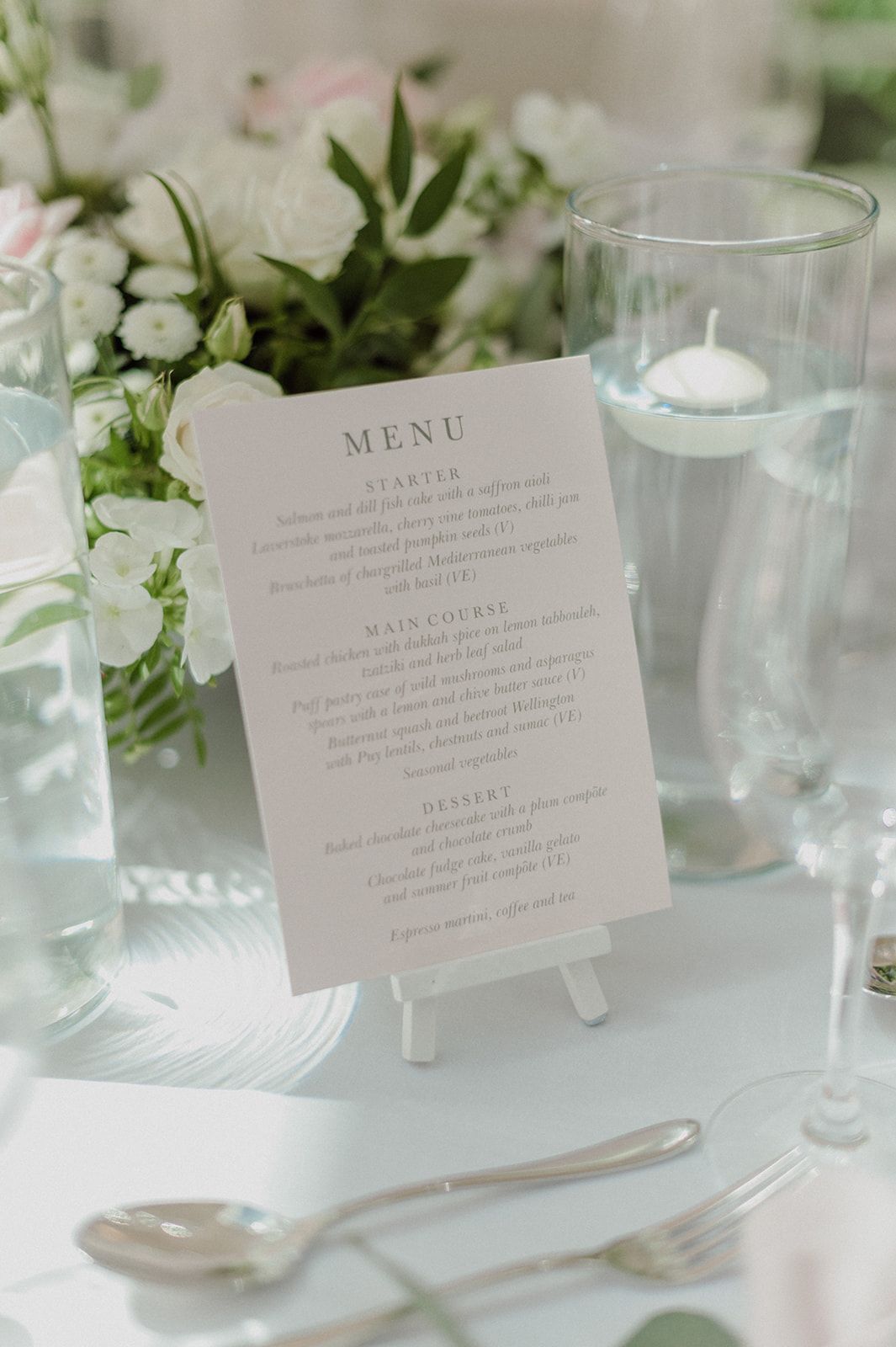 a menu is sitting on a table next to a vase of flowers.