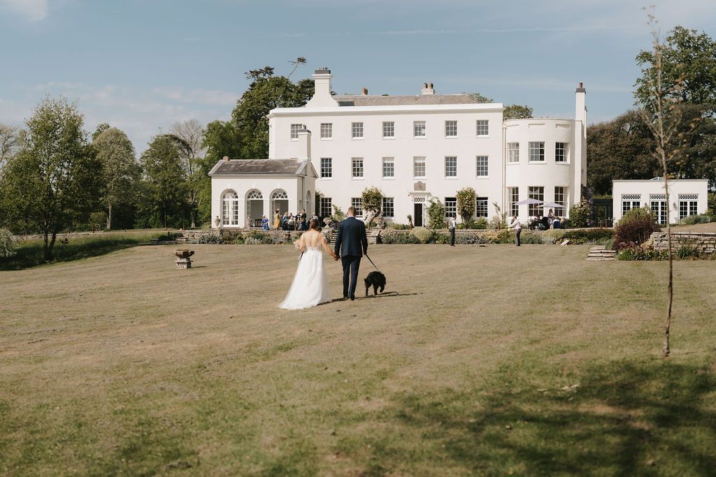 a bride and groom are posing for a picture in front of a large white building .