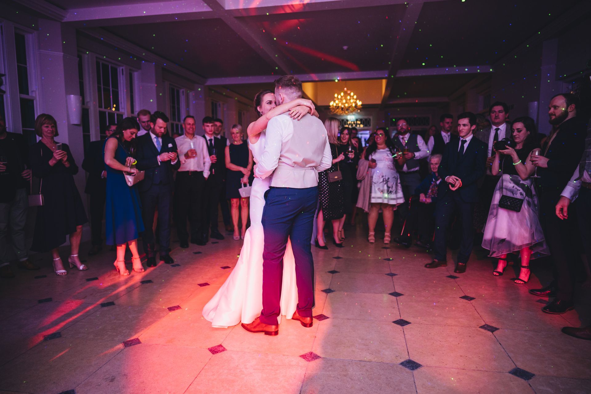 a bride and groom are dancing their first dance at their wedding reception .