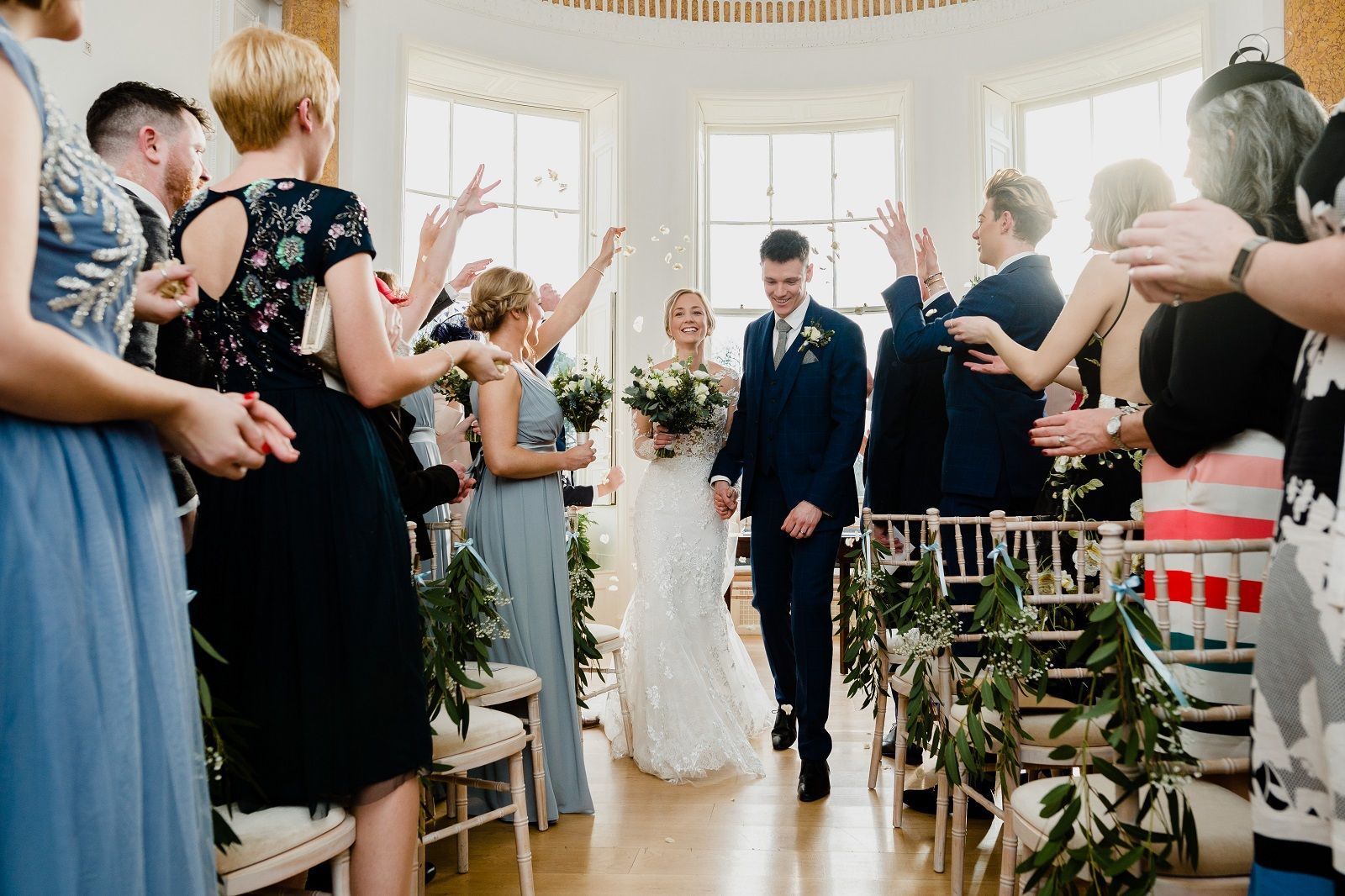 a bride and groom are walking down the aisle at their wedding .