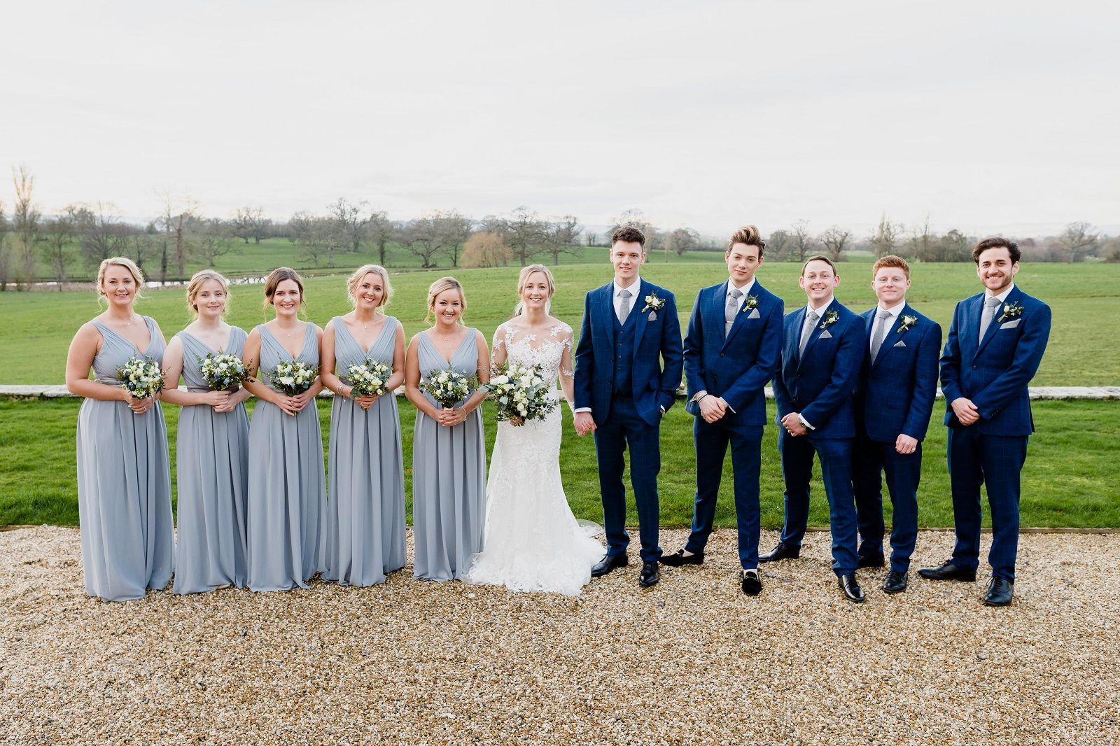 the bride and groom are posing for a picture with their wedding party .