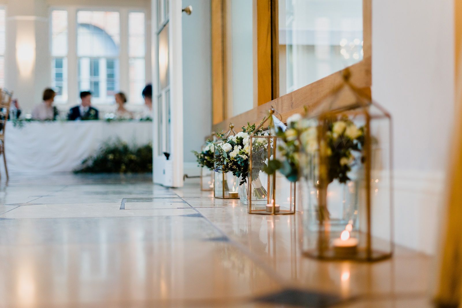 a row of vases filled with flowers and candles on a table .