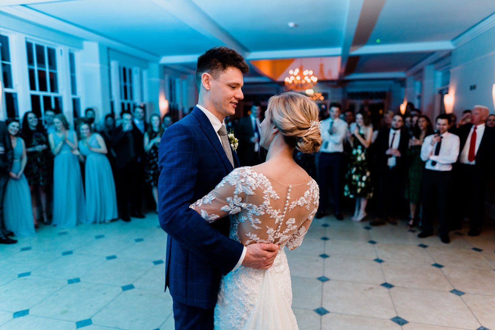 a bride and groom are dancing in front of a crowd at their wedding reception .
