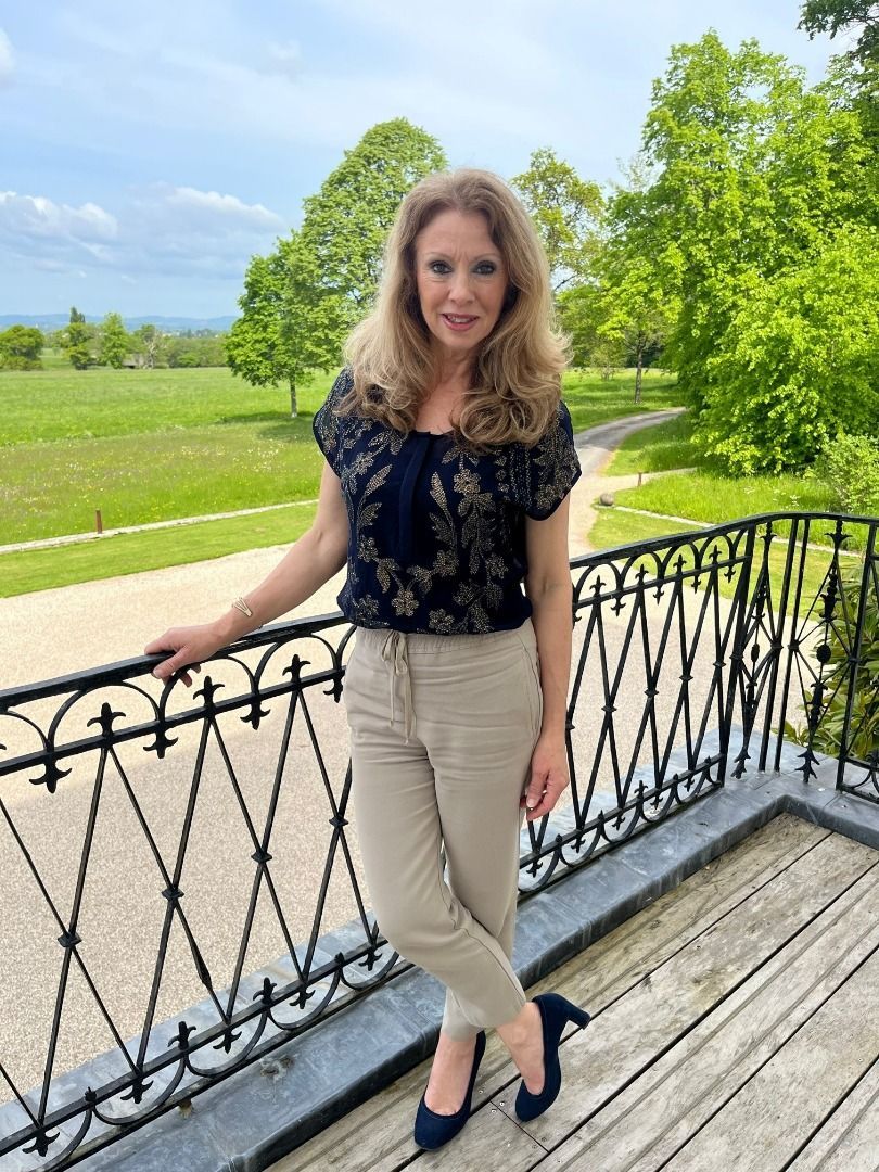 a woman is standing on a balcony leaning on a railing .