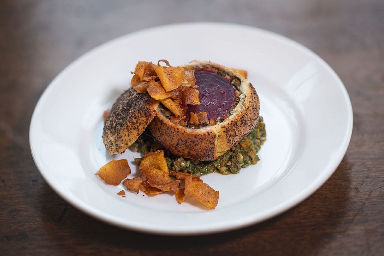 a white plate topped with a piece of food on a table .