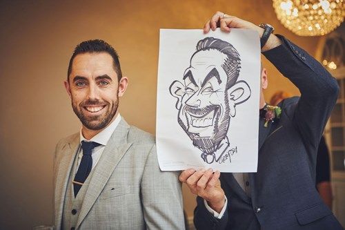 a man in a suit and tie is holding a caricature of himself .