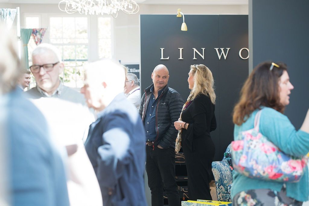 a group of people are standing in front of a linwood sign .