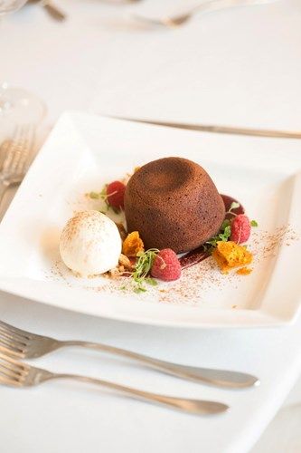 a white plate topped with a chocolate cake and ice cream on a table .