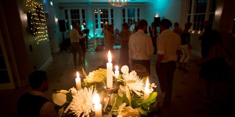 a group of people are standing around a table with candles and flowers .
