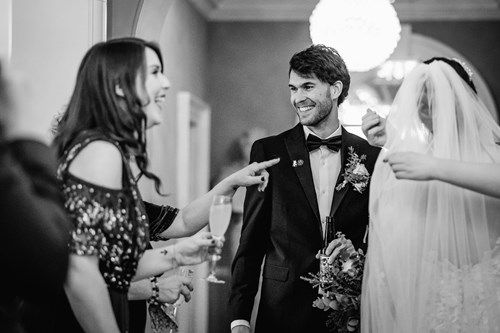a black and white photo of a bride and groom standing next to each other .