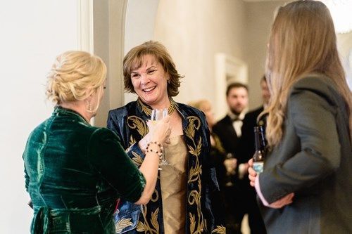 a group of women are standing next to each other and talking .