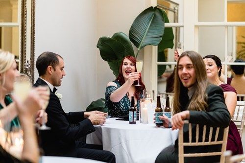 a group of people are sitting at a table drinking champagne .