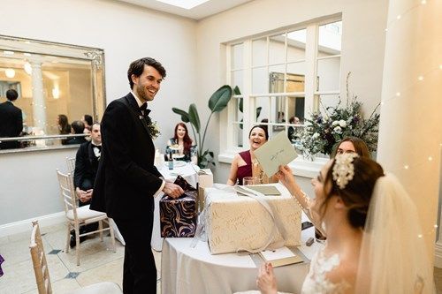 a bride and groom are standing next to each other in a room at a wedding reception .