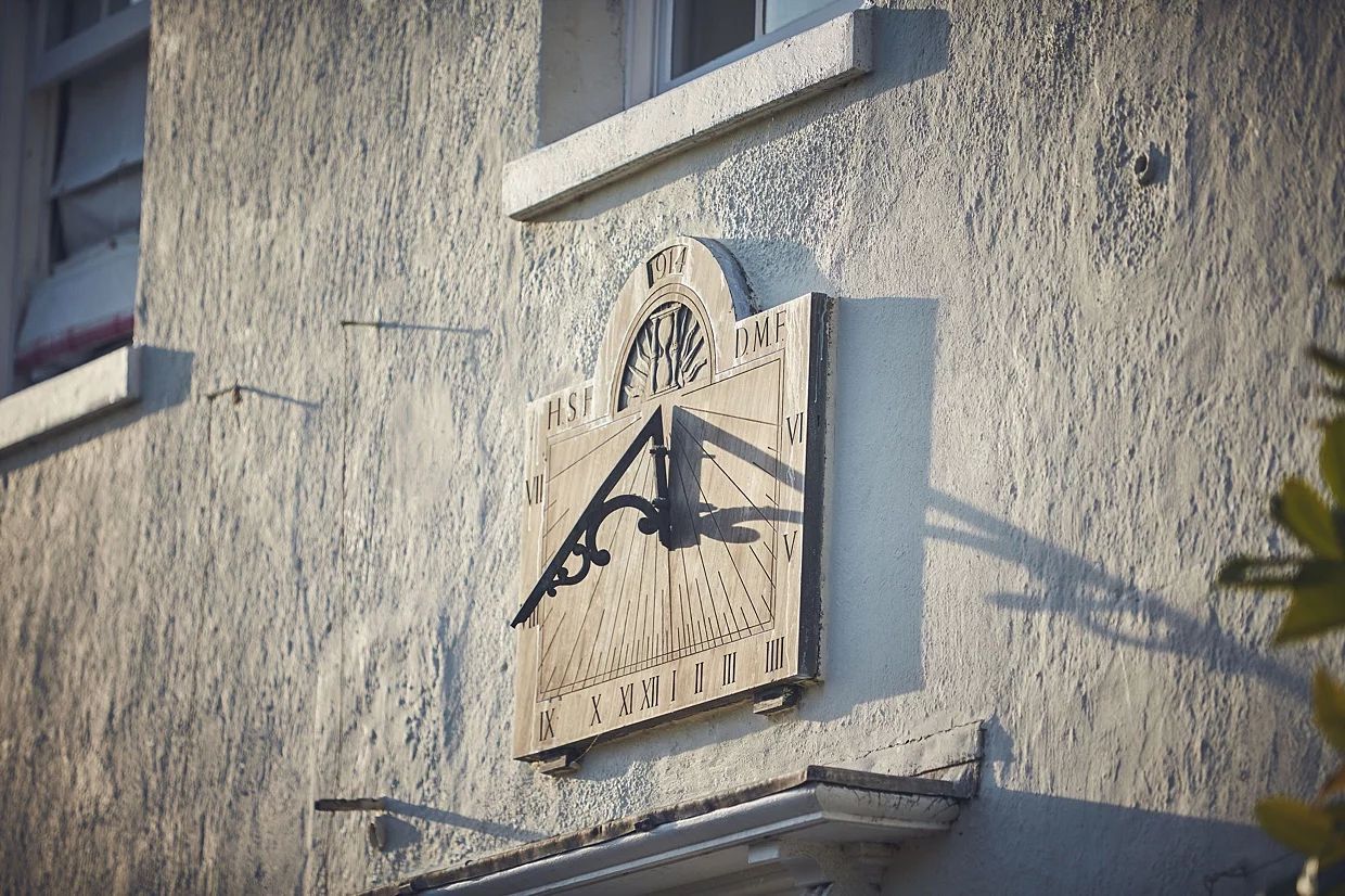 a clock on the side of a building with the letter a on it