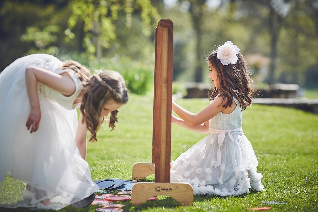 two little girls are playing a game in the grass .