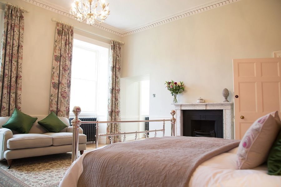 a bedroom with a bed , couch , and fireplace .