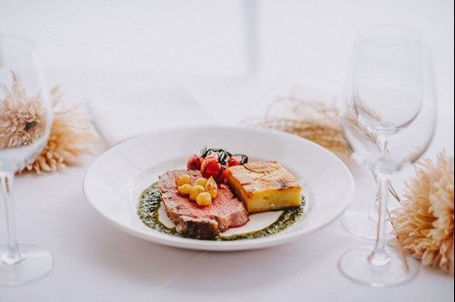 a plate of food is sitting on a table next to wine glasses .