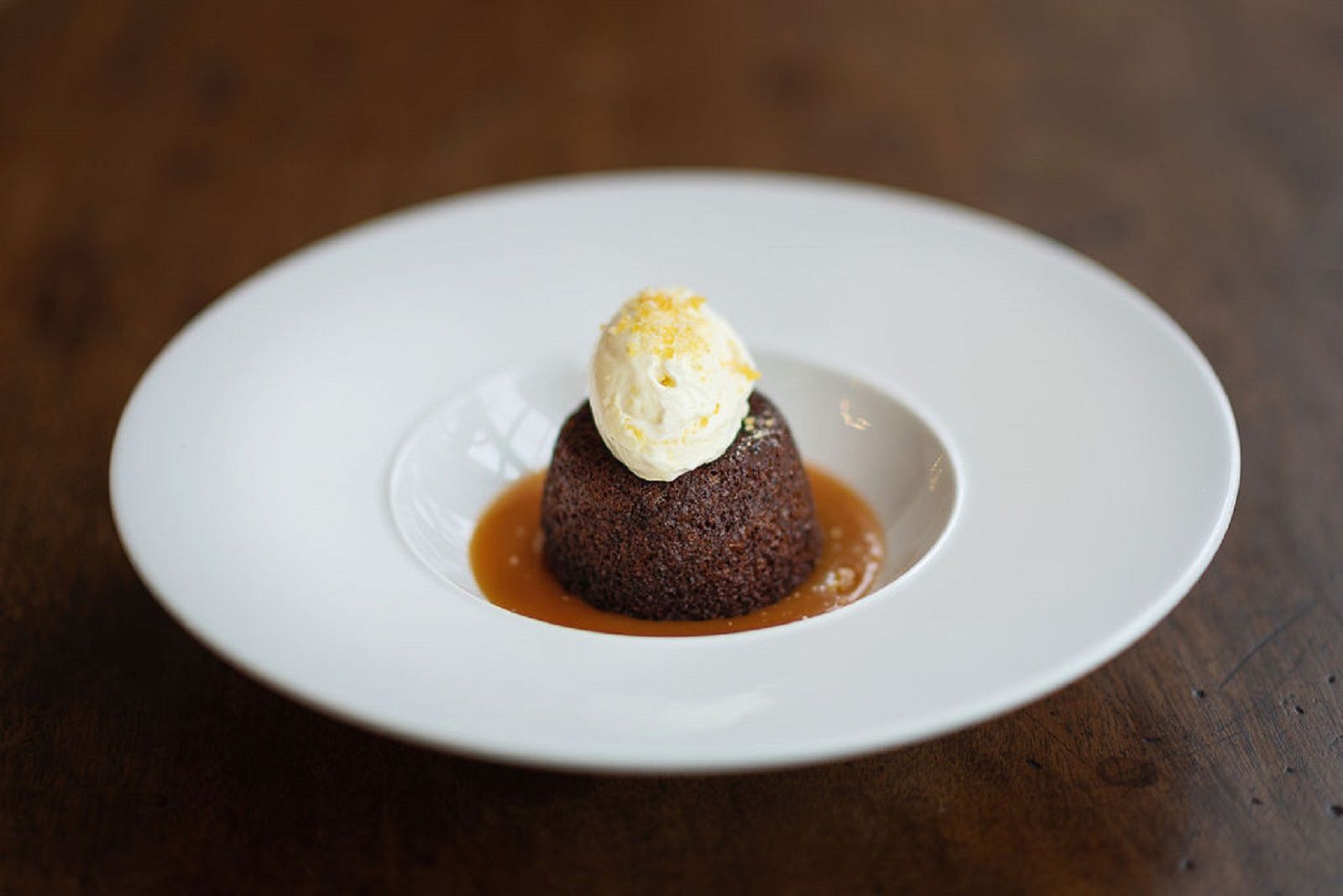 a white plate topped with a chocolate pudding and ice cream .
