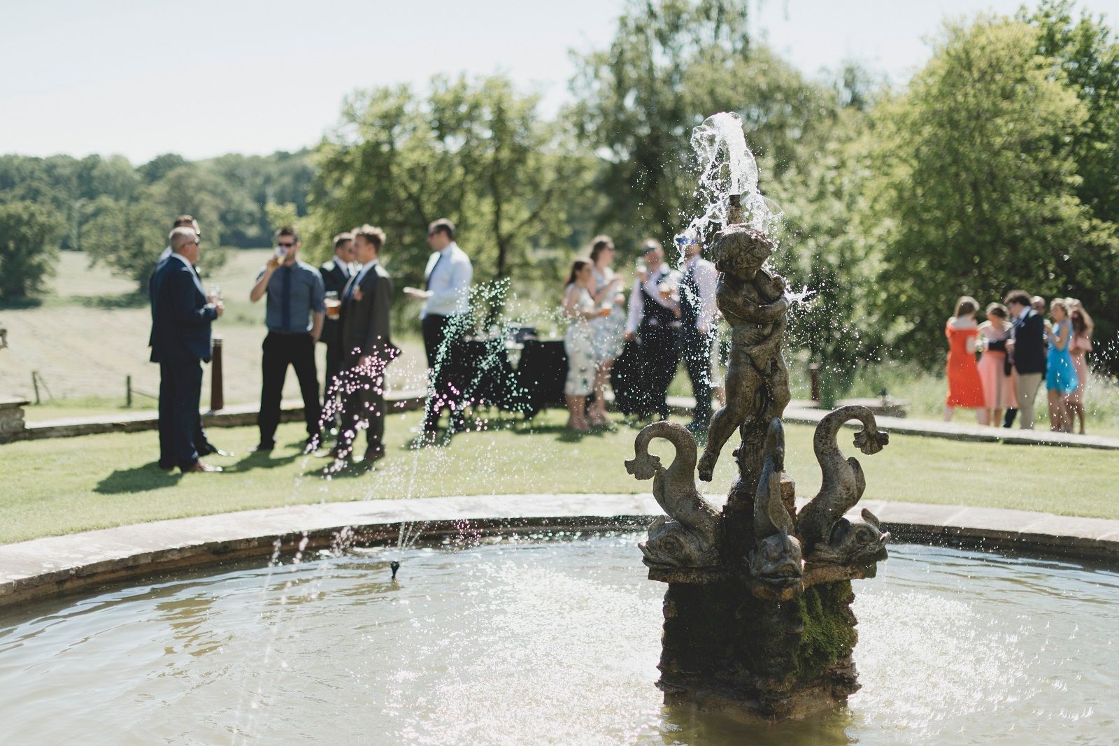 a group of people are standing around a fountain .
