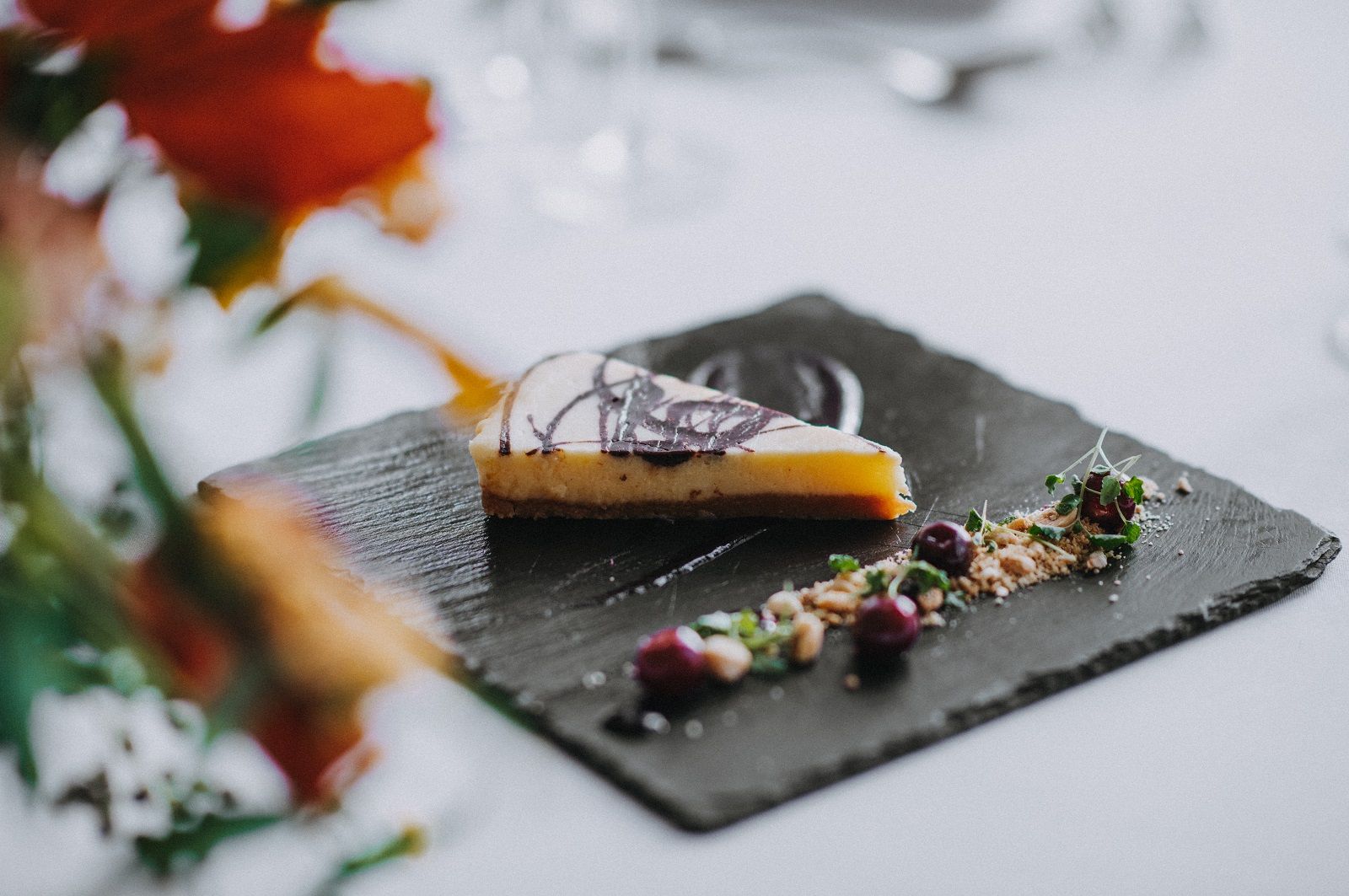 a slice of cheesecake is on a black plate on a table .