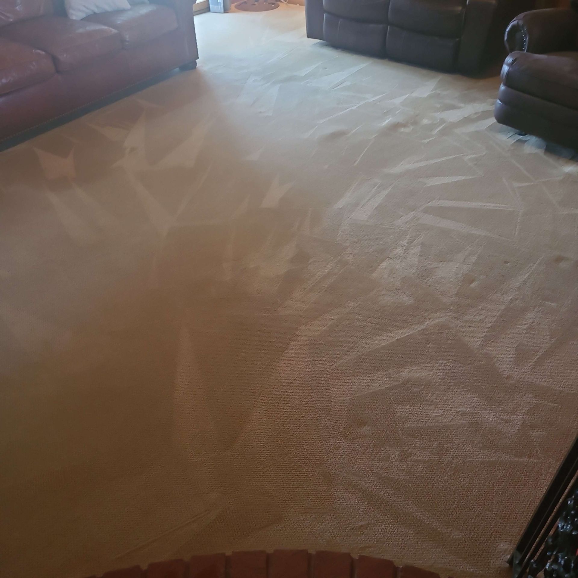 A living room with a couch , chair , fireplace and carpet.