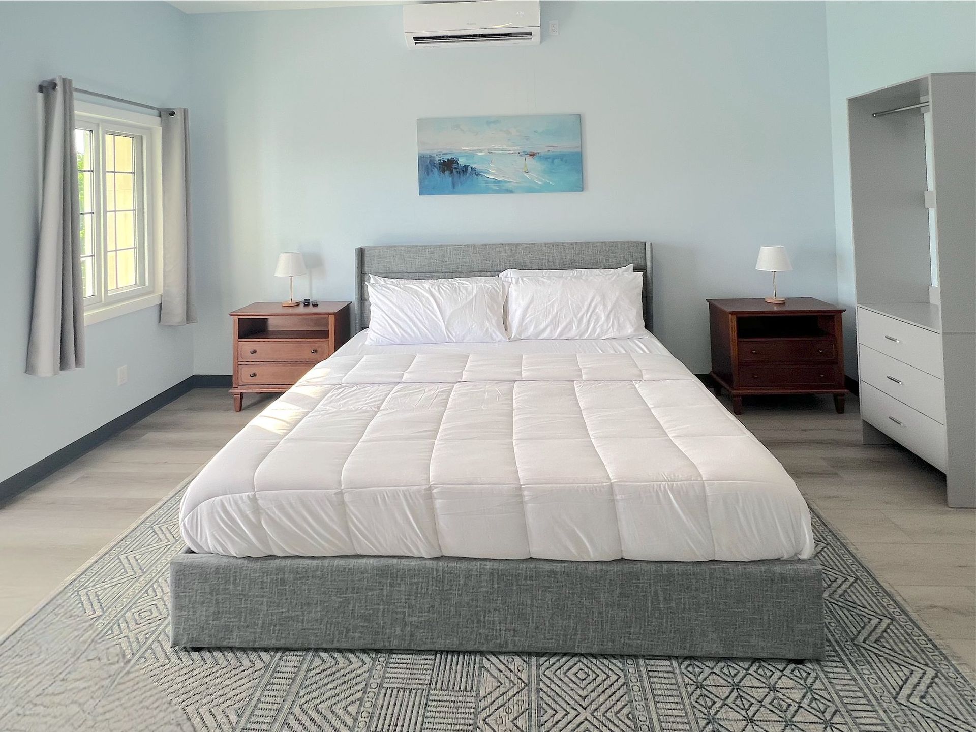 A black and white cow is standing in a field looking at the camera.