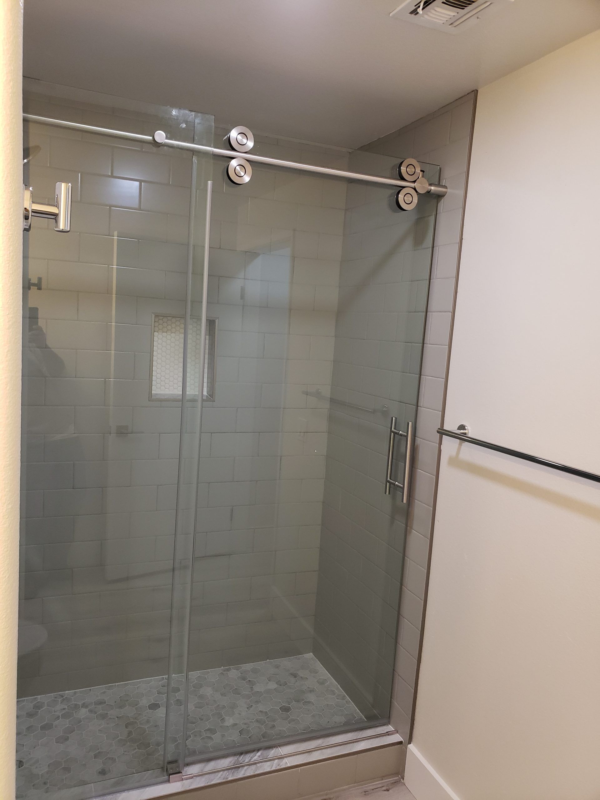 A bathroom with a sliding glass shower door from a Bathroom remodel in San Diego CA by Team  Renovate