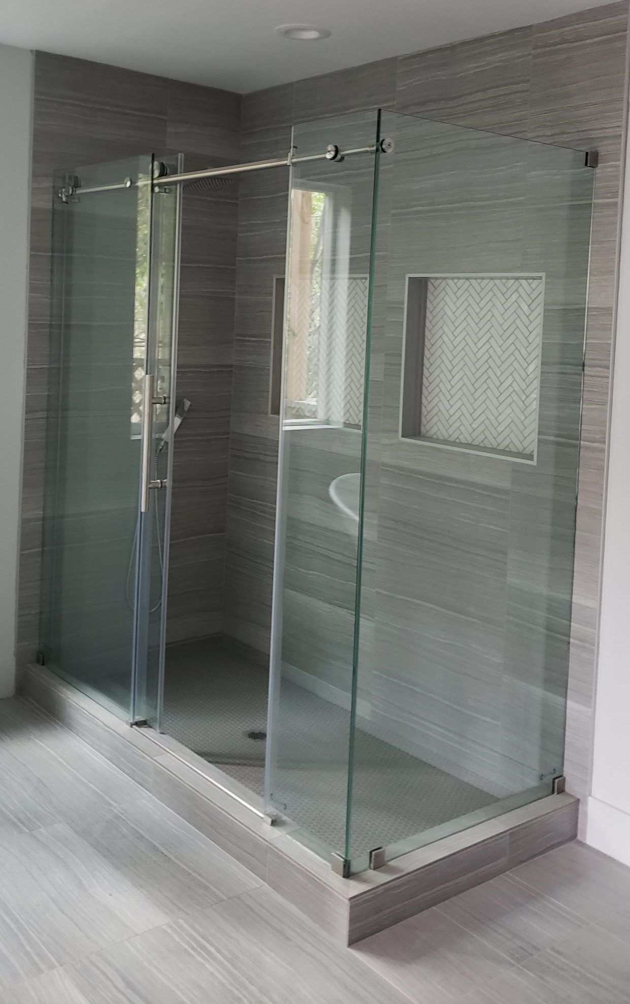 A bathroom with a sliding glass shower door and a sink.