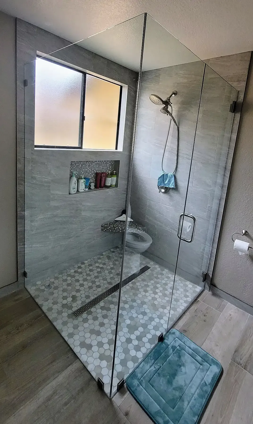 A bathroom with a walk in shower and a toilet.
