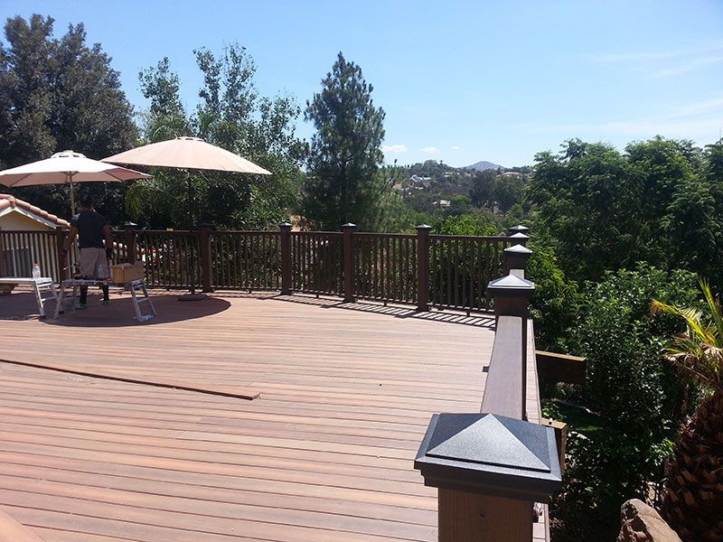A wooden deck with umbrellas and chairs on it