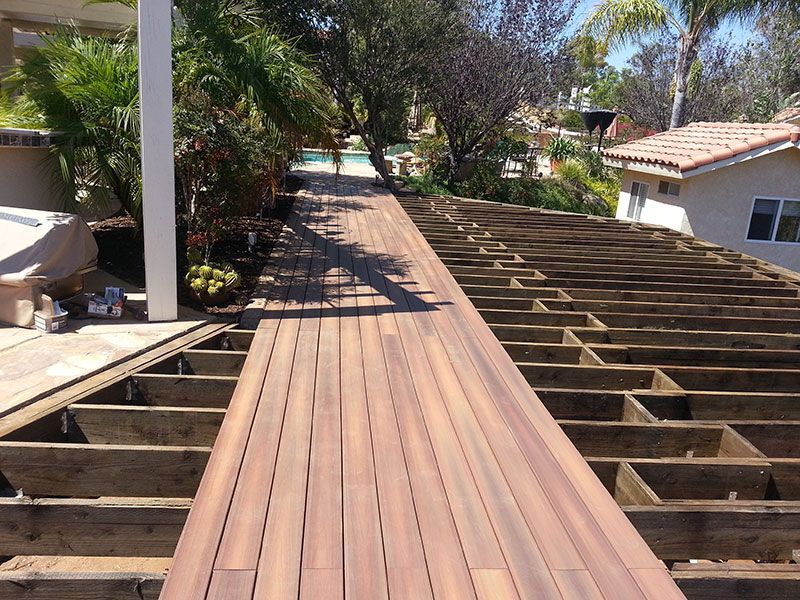 A wooden deck with a hot tub in the background