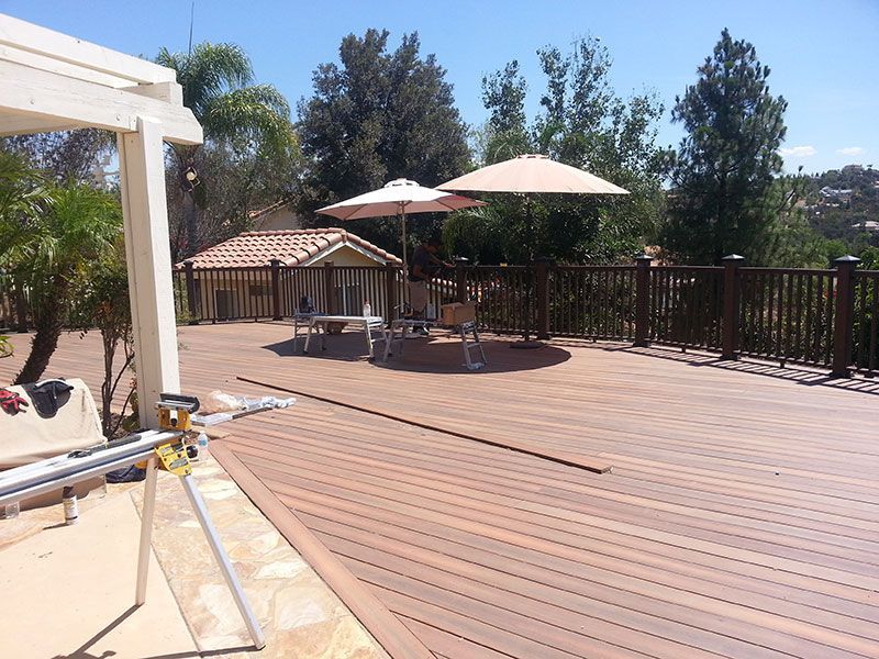 A wooden deck with umbrellas and chairs on it