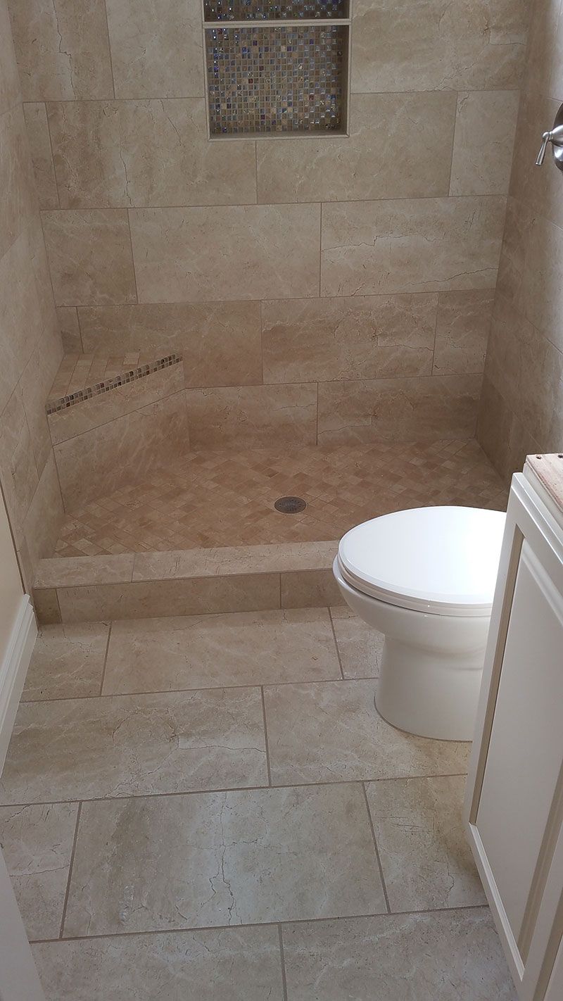 A bathroom with a toilet and a walk in shower from a Bathroom remodel in San Diego CA by Team  Renovate
