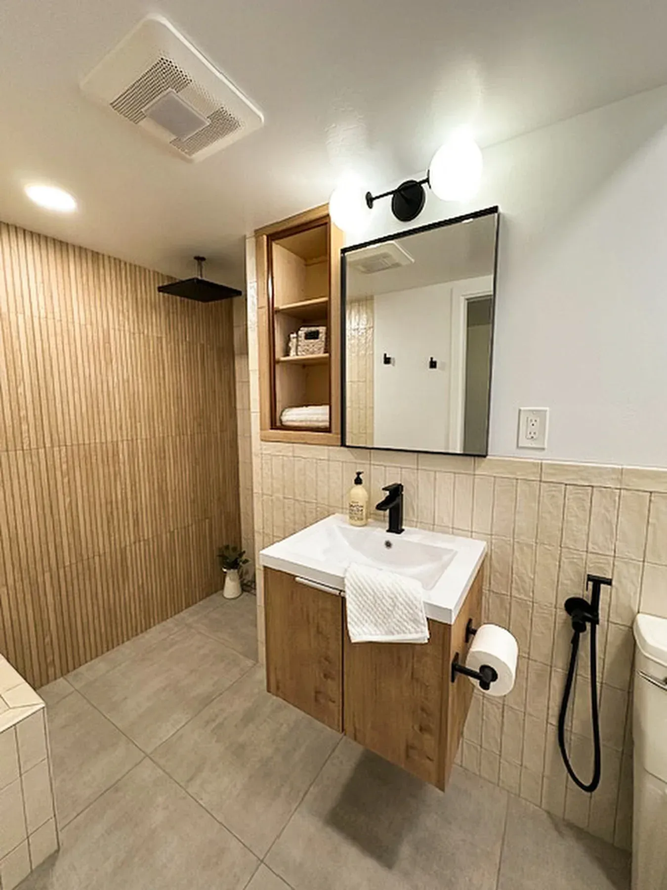 A bathroom with a sink , mirror , toilet and shower from a Bathroom remodel in San Diego CA by Team  Renovate