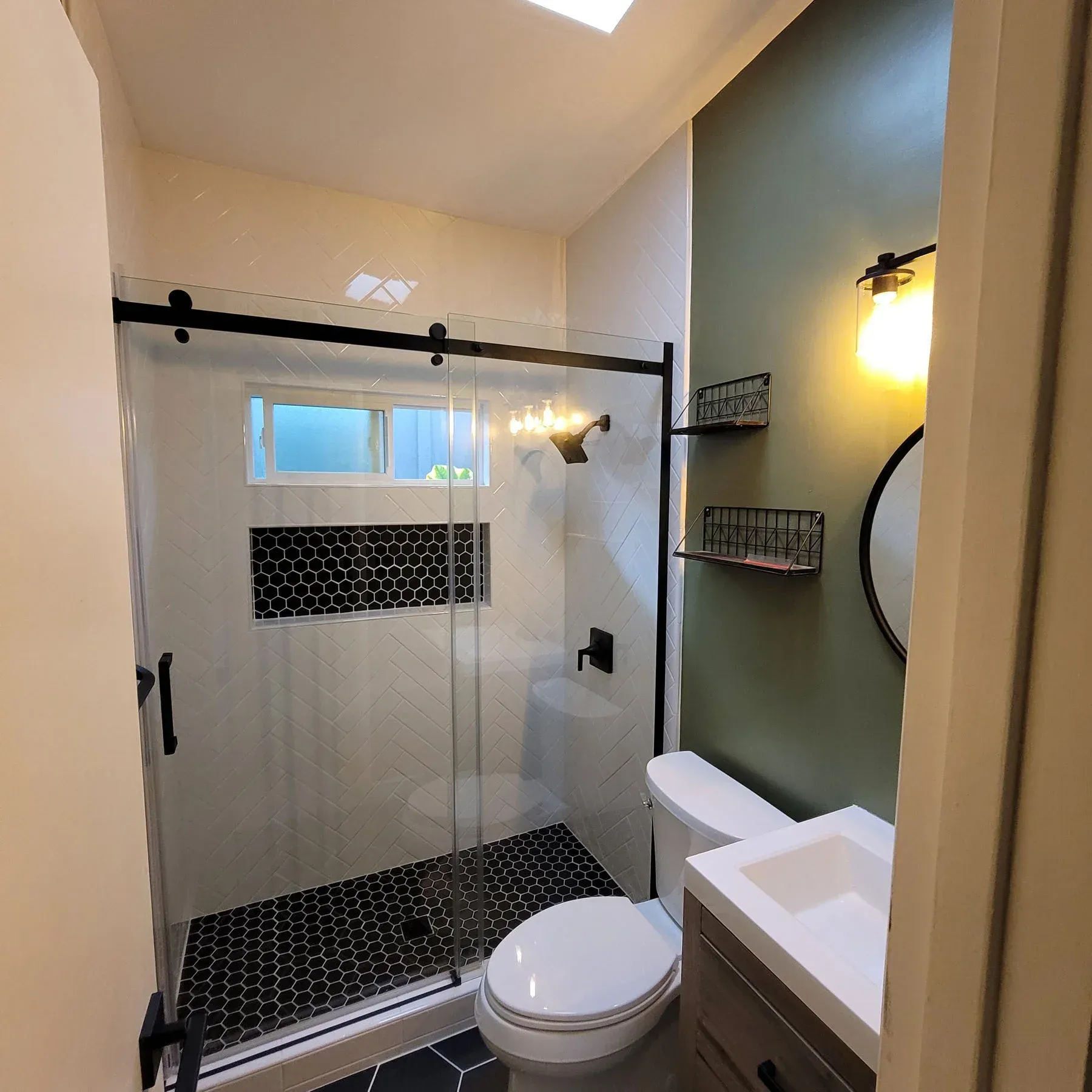 A bathroom with a walk in shower and a window from a Bathroom remodel in San Diego CA by Team  Renovate
