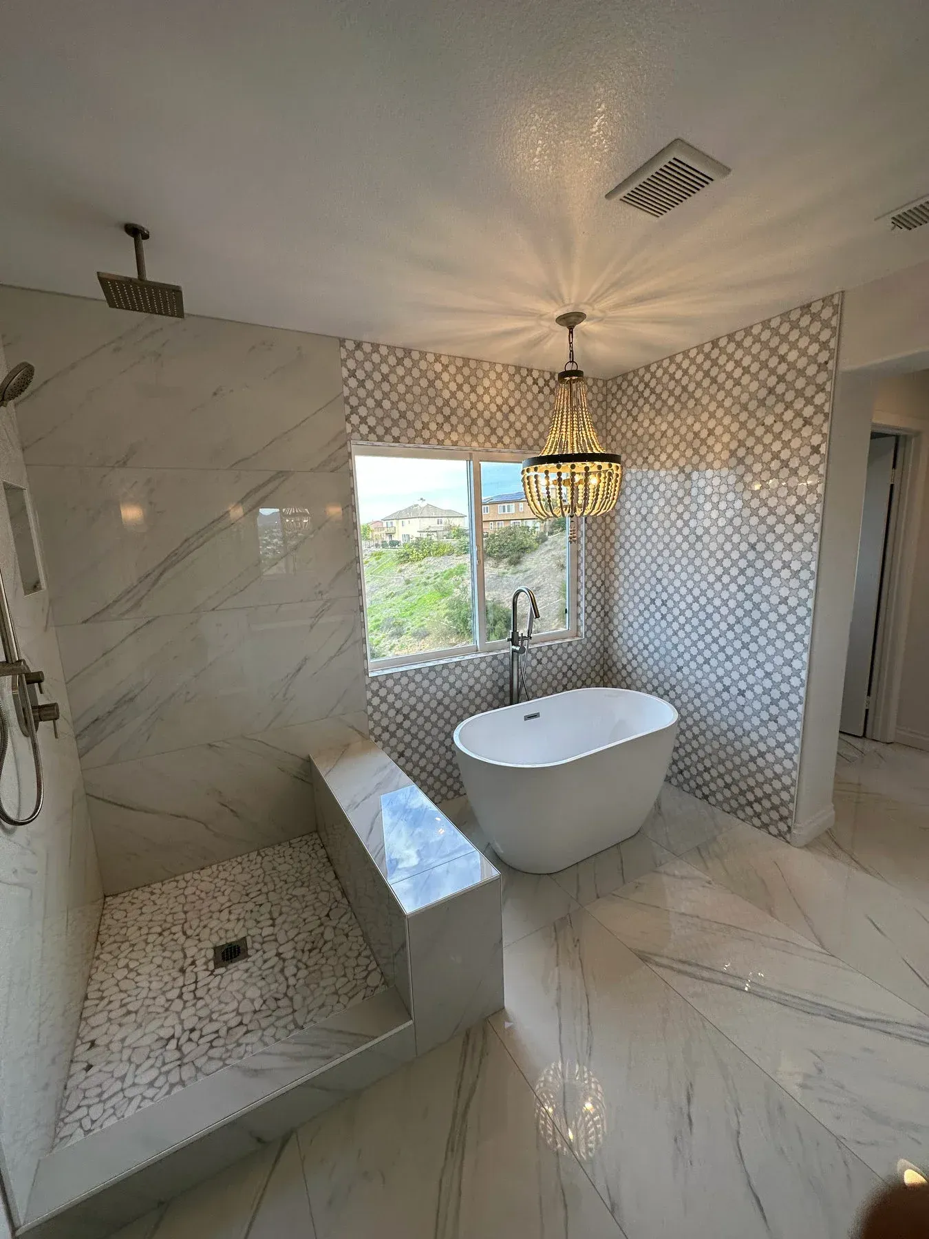 A bathroom with a tub , shower , and window from a Bathroom remodel in San Diego CA by Team  Renovate
