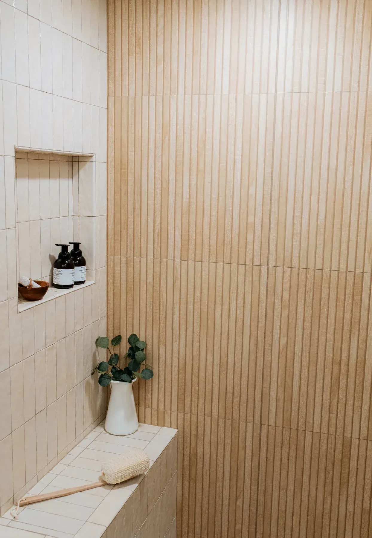 A bathroom with a shower , a shelf , a plant and a brush. from a Bathroom remodel in San Diego CA by Team  Renovate