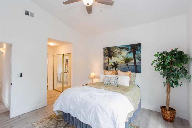 A bedroom with a large bed and a ceiling fan.
